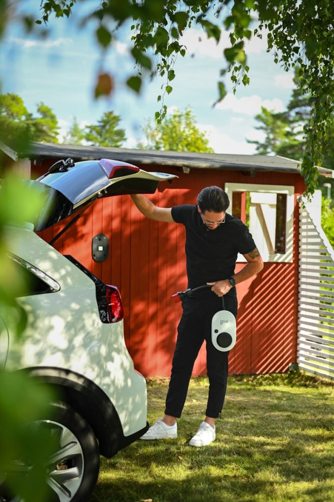 Man prepares to charge electric car.