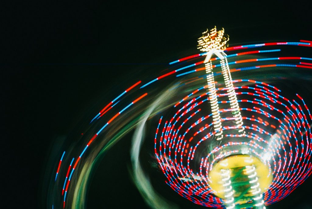 A ferris wheel spinning at night with a blurry background